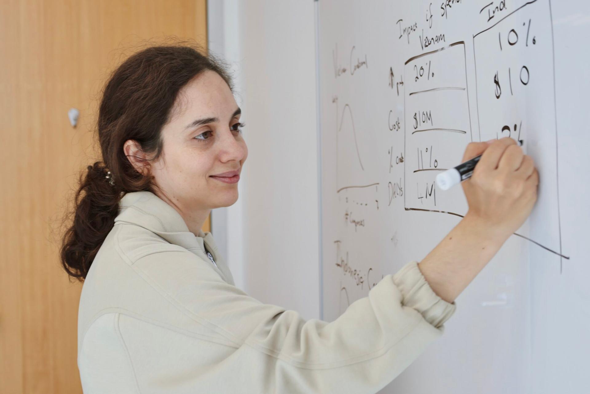 La imagen muestra a Emma Buckland esbozando un breve cálculo de servilleta para sus colegas.