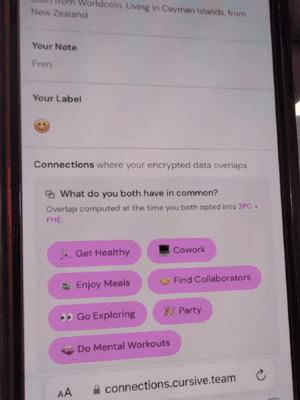 Captura de pantalla en un teléfono de la aplicación Cursive connections, que muestra el perfil de un usuario con una nota, una etiqueta de cara sonriente y una sección que enumera intereses compartidos calculados a partir de la superposición de datos cifrados con otro usuario. Texto: de Worldcoin. Vive en las Islas Caimán, viene de Nueva Zelanda. Tu nota. Colega. Tu etiqueta. Conexiones en las que tus datos cifrados se superponen. ¿Qué tienen ambos en común? Superposición calculada en el momento en que ambos aceptaron 2PC + FHE. Ponerse en forma. Coworking. Disfrutar de comidas. Encontrar colaboradores. Salir a explorar. Fiesta. Ejercicios mentales. connections.cursive.team.