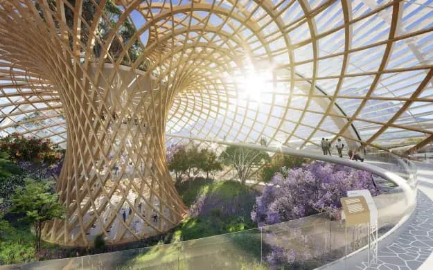 Render arquitectónico de una cúpula de celosía de madera entrelazada que se abre a una pradera soleada de flores silvestres y lavanda, con visitantes caminando por un sendero elevado y curvo entre la vegetación.