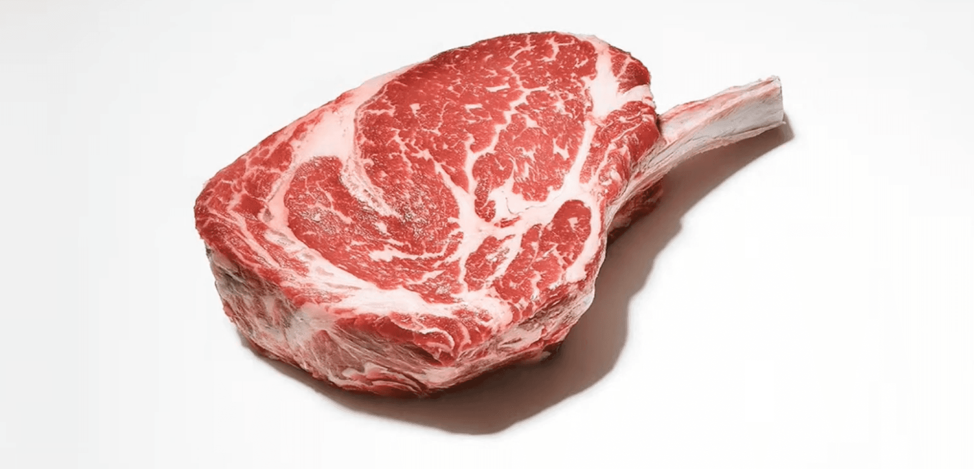 La imagen muestra un corte de carne roja, que parece ser un ribeye o un filete con un buen marmoleo.